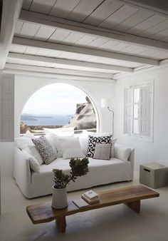 Soggiorno mediterraneo con arco e divano bianco